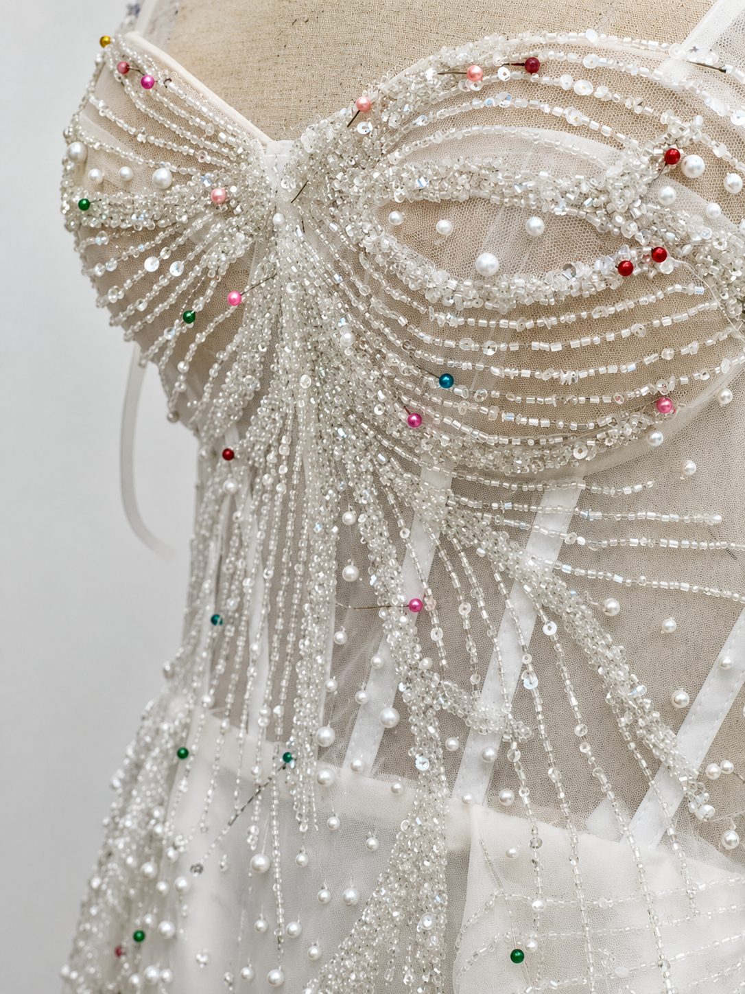 Hand beaded pearl draping pinned in progress on a couture bodice
