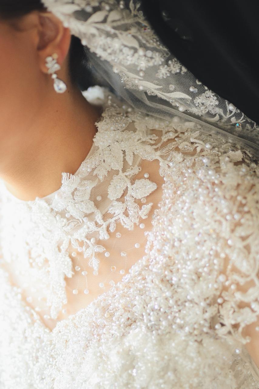 Close-up of hand-beaded lace on a couture bridal bodice